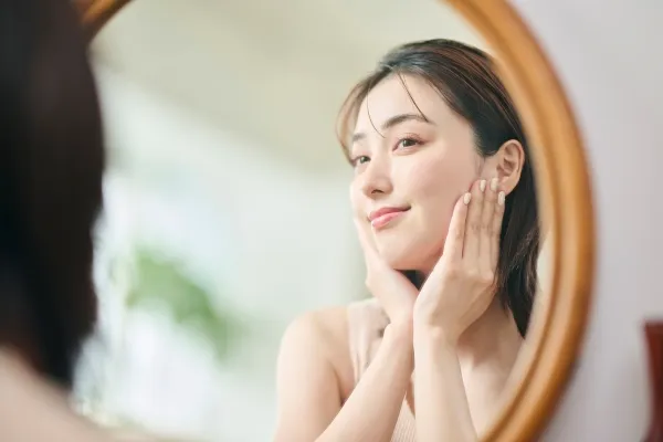 鏡で自身の顔を確認する女性