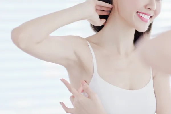 鏡で脇の状態を確認する女性