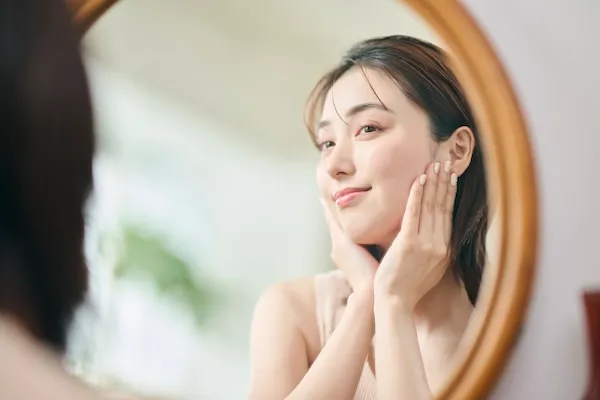 鏡で自身の顔を確認する女性